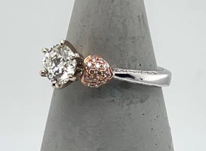 White gold ring with round diamond and rose gold pavé heart accents.