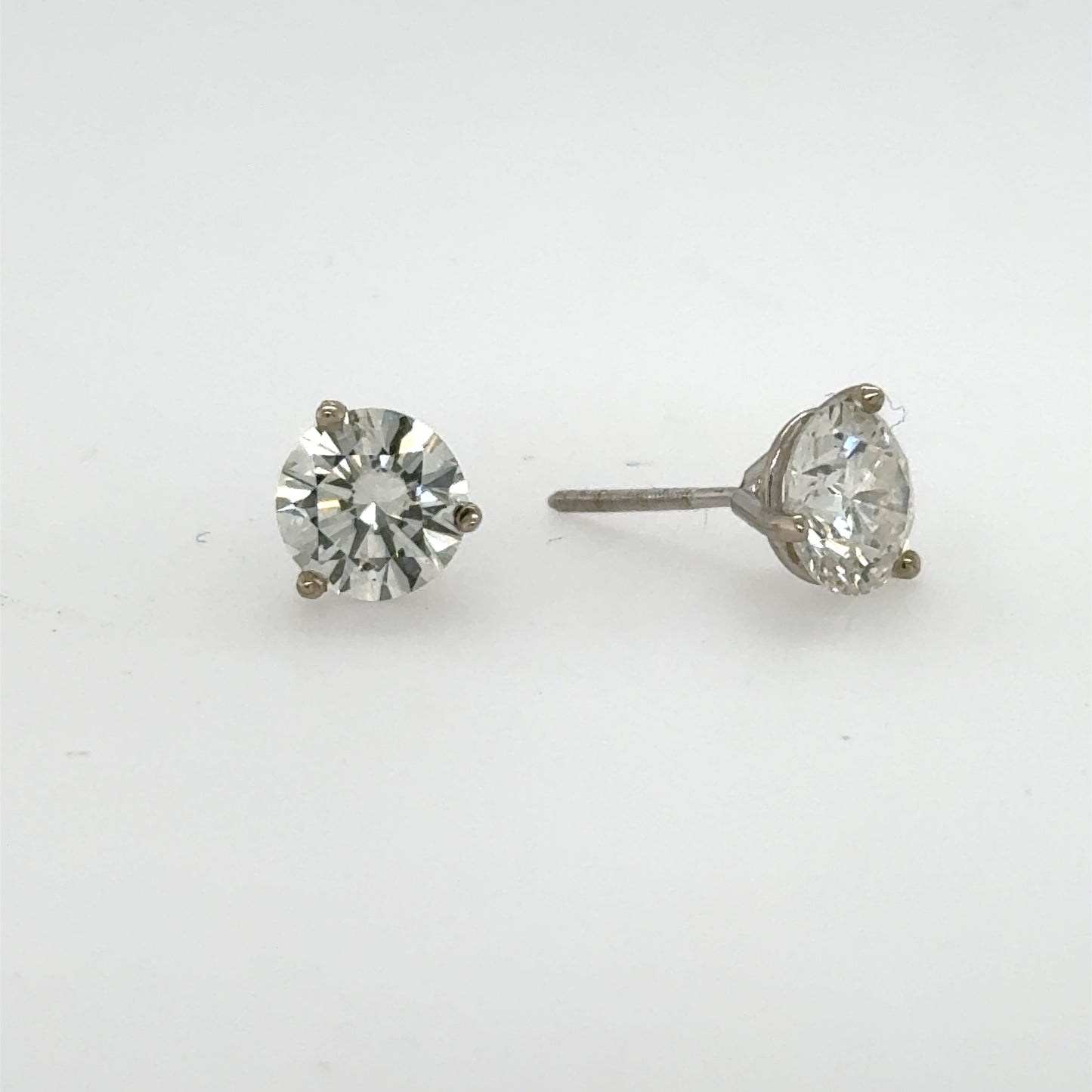 Round brilliant diamond stud earrings in white gold three-prong martini settings.