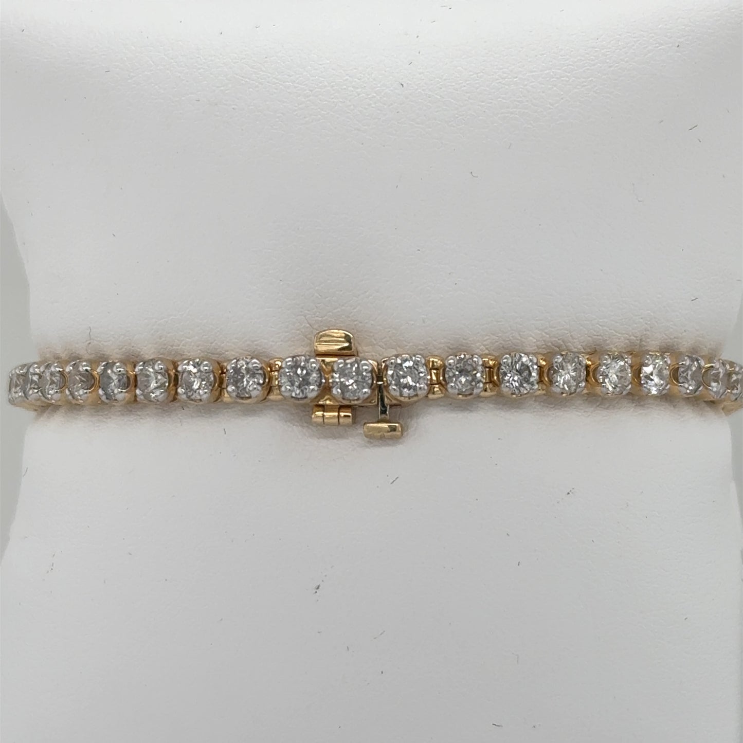 14K yellow gold tennis bracelet with round diamonds in four-prong settings, hidden clasp.