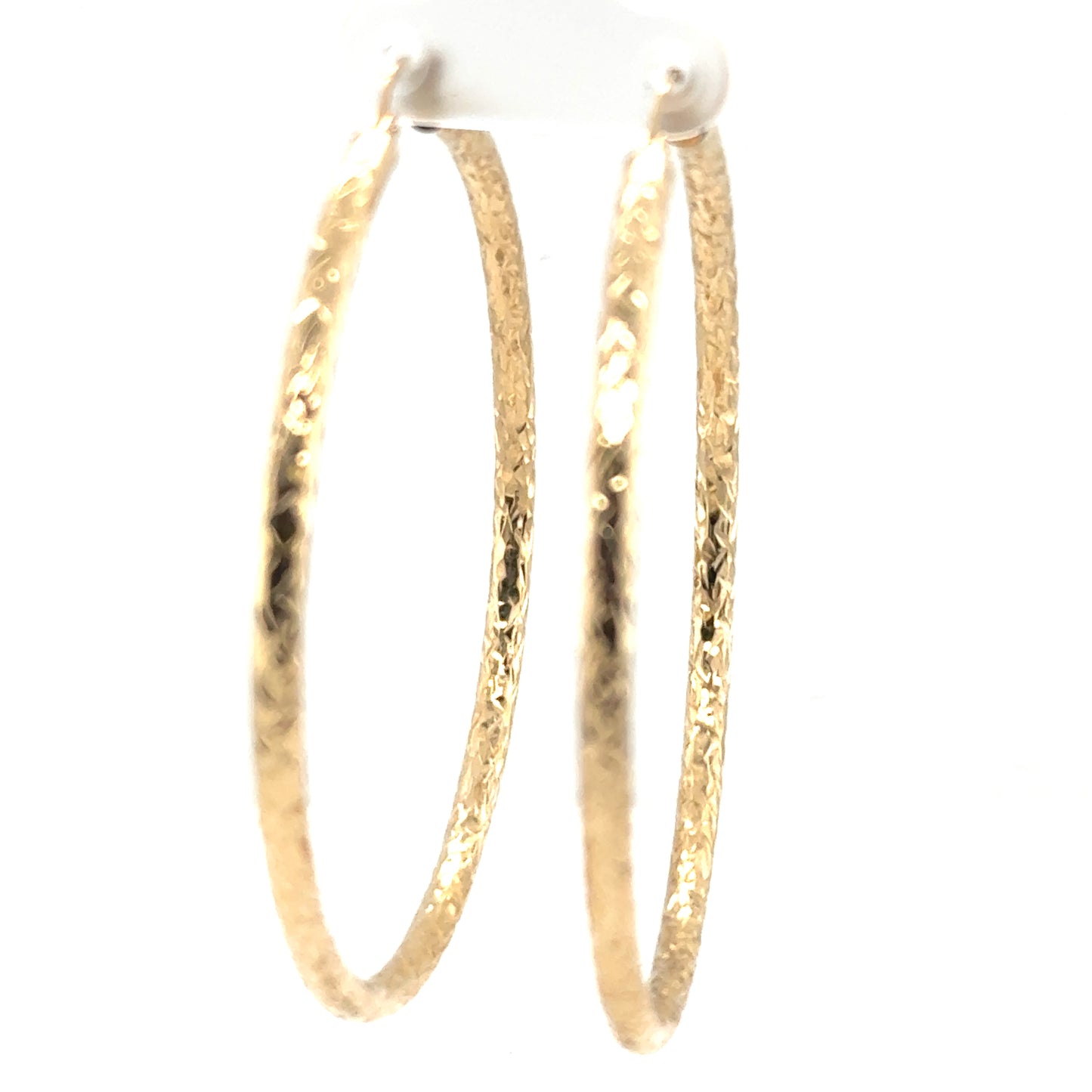 Extra large 14K yellow gold hoop earrings with diamond-cut textured tube design.
