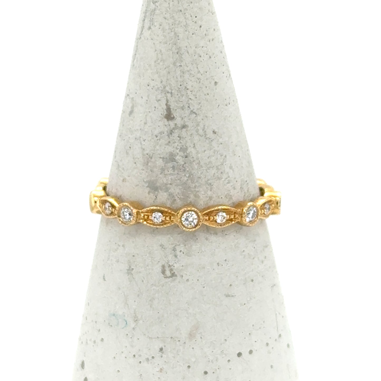 18K yellow gold stackable band with bezel-set round diamonds and milgrain detailing.