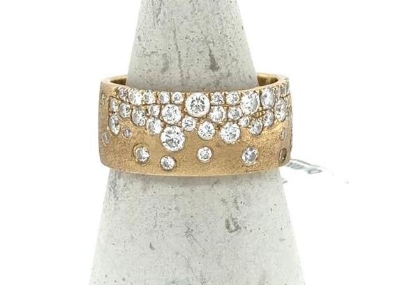 Wide 14K yellow gold band with flush-set round diamonds in confetti pattern.