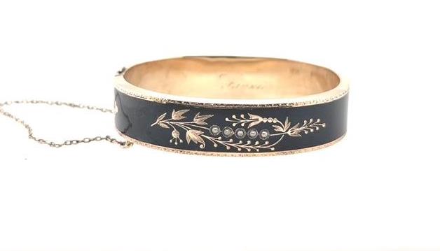 10K yellow gold Victorian bangle with black enamel, seed pearls, and safety chain.