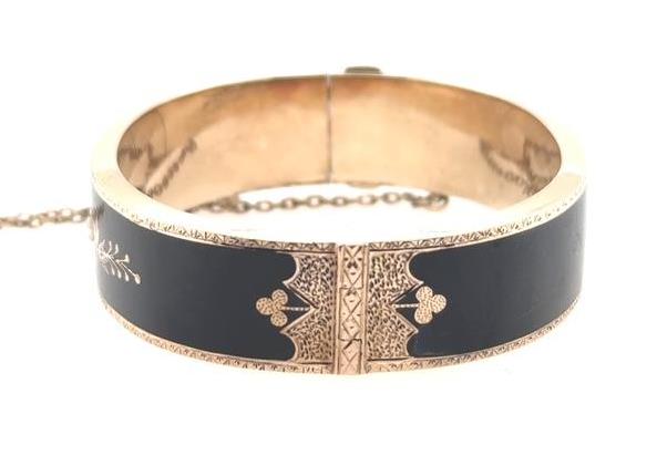 10K yellow gold Victorian hinged bangle with black enamel panels and safety chain.