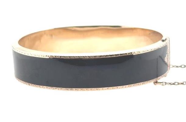Wide 10K yellow gold bangle with glossy black enamel and safety chain.
