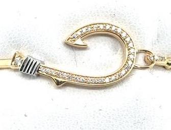Yellow gold fish hook bangle with pavé diamonds and white gold wrap detail.