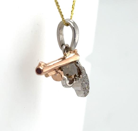 14K rose and white gold pistol pendant with diamond grip and ruby tip.