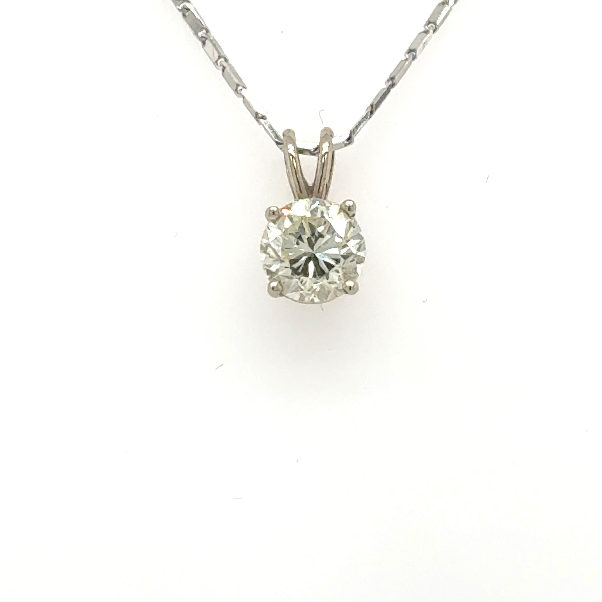 Round brilliant diamond solitaire in 14K white gold four-prong pendant setting.