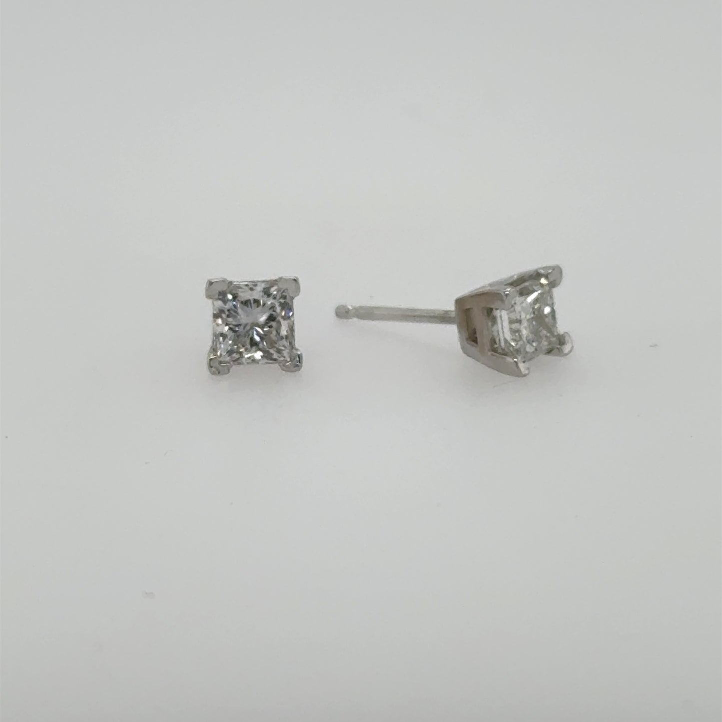 Princess-cut diamond stud earrings in white gold, four-prong settings with friction posts.