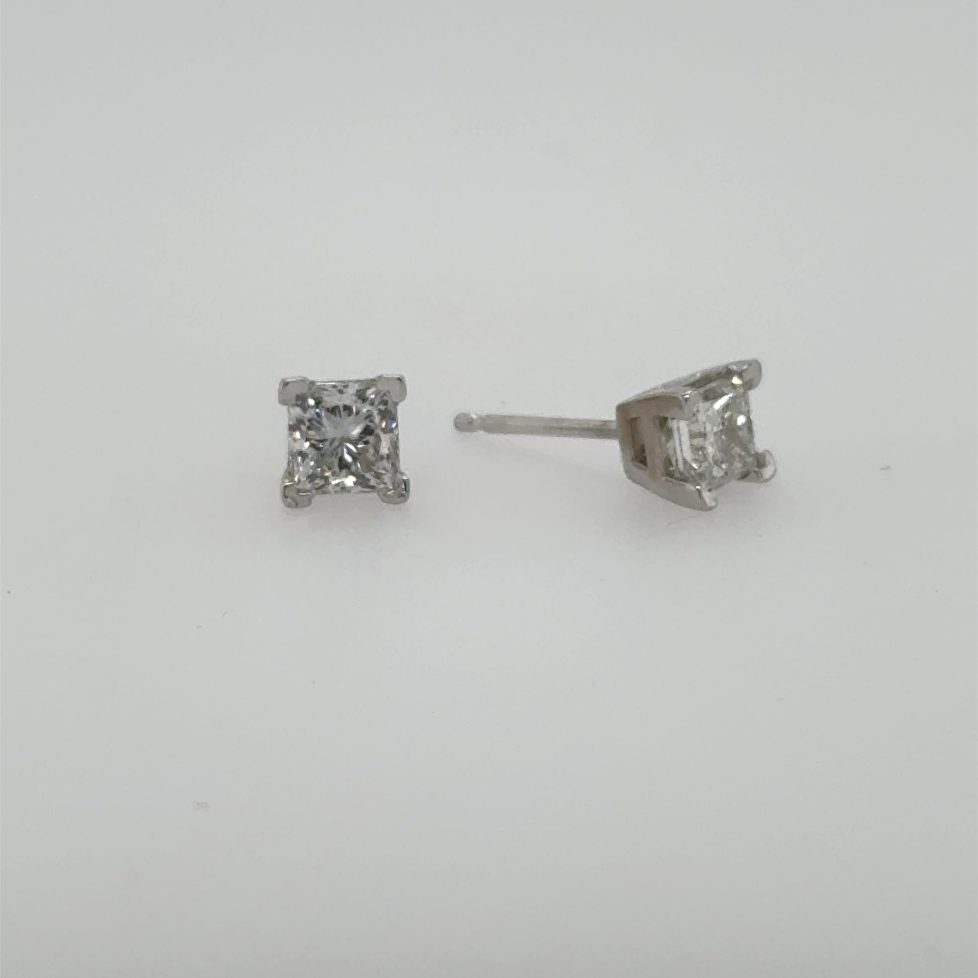 Princess-cut diamond stud earrings in white gold, four-prong settings with friction posts.