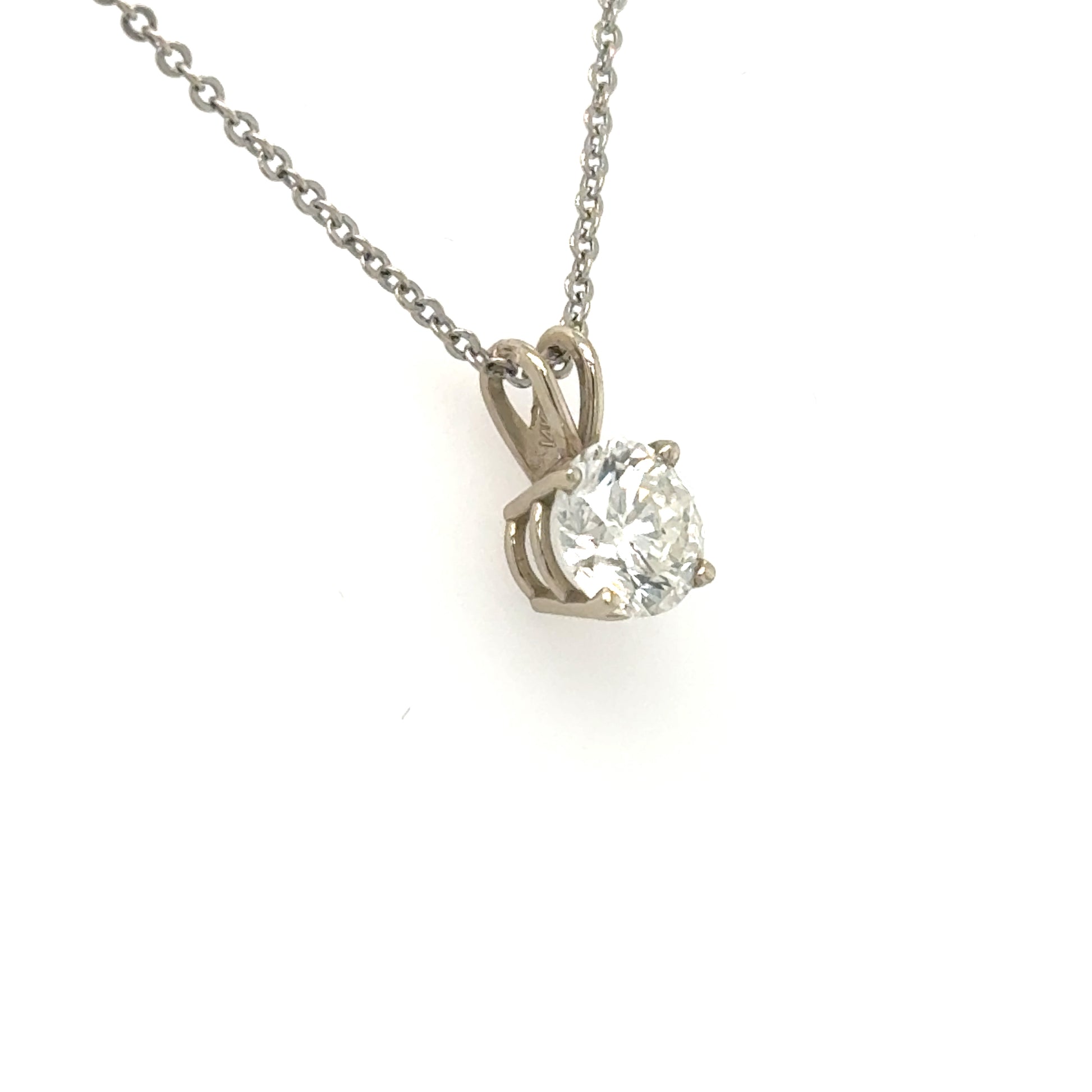 White gold solitaire pendant with round diamond in four-prong basket and rabbit-ear bail.