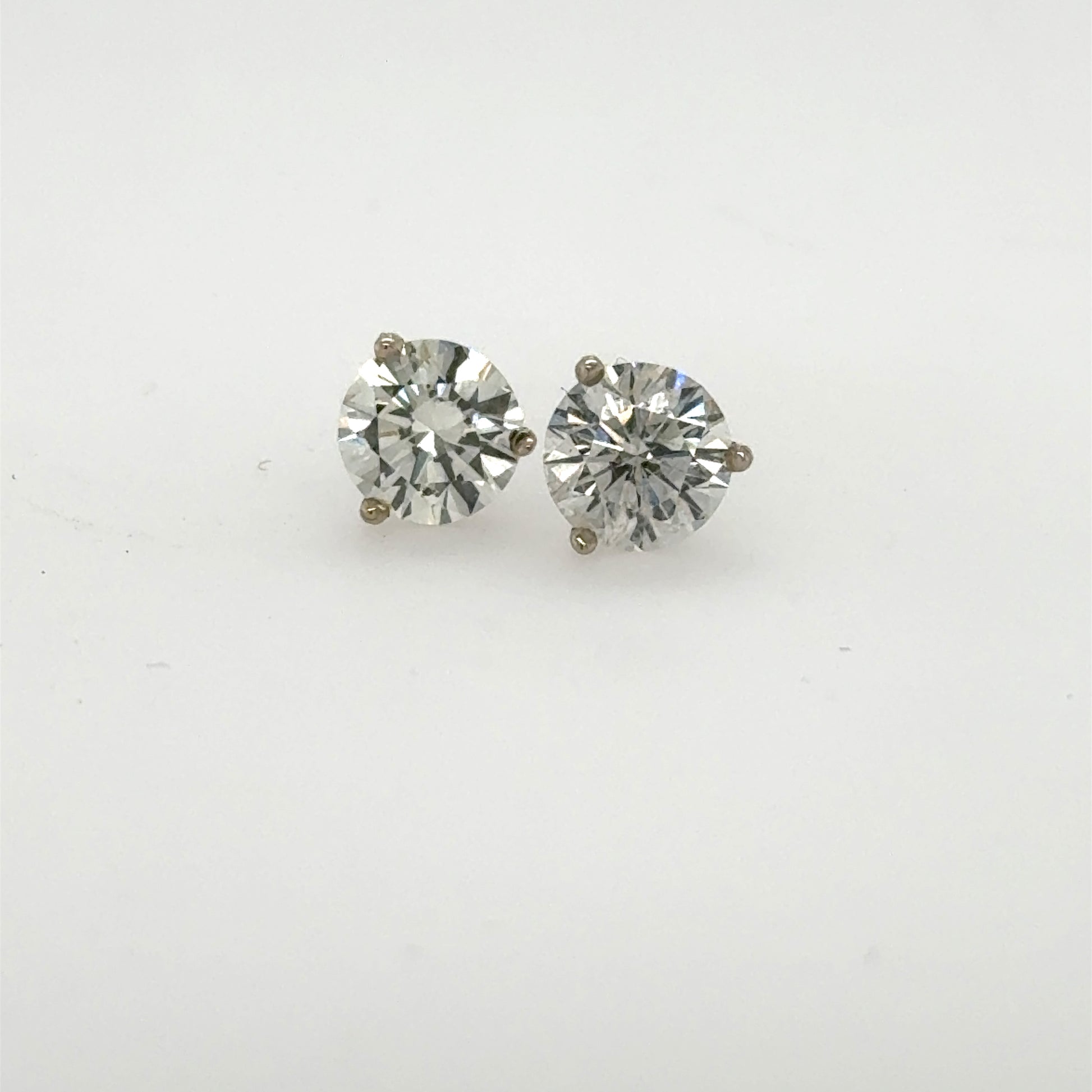 Round brilliant diamond stud earrings in 14K white gold three-prong martini settings.