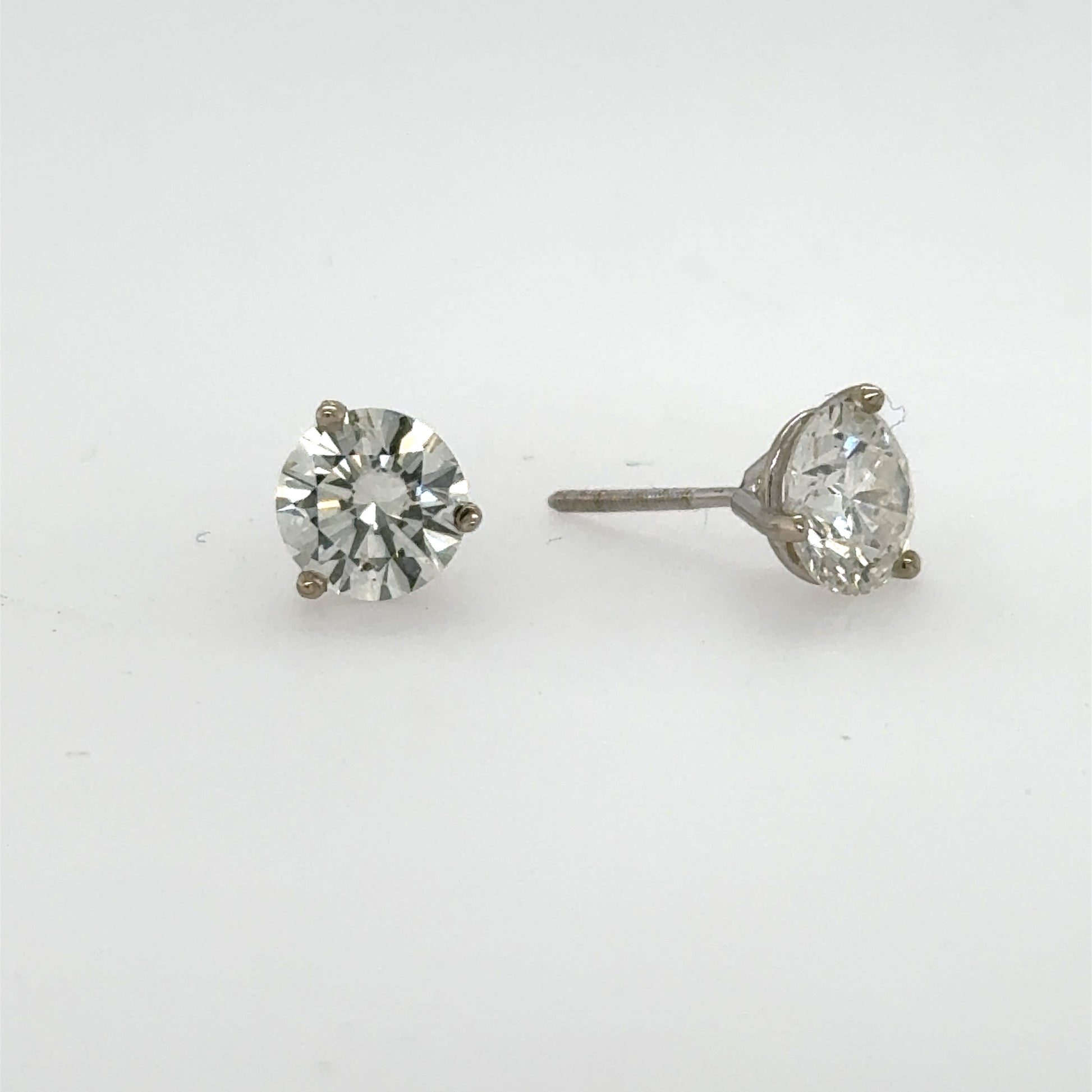 Round brilliant diamond stud earrings in white gold three-prong martini settings.