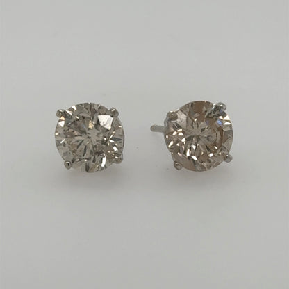 Round diamond stud earrings in white gold four-prong basket settings with posts.