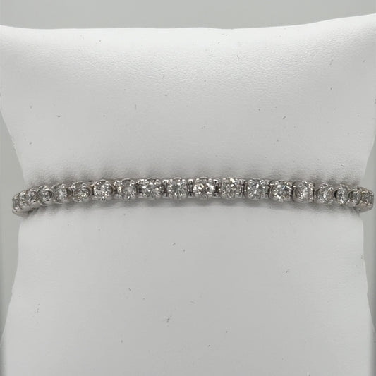 14K white gold tennis bracelet with round diamonds in prong-set straight line.
