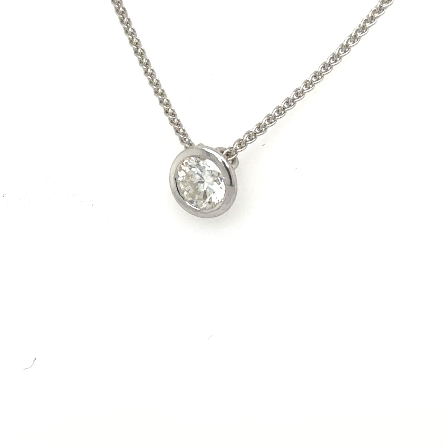 Round diamond bezel pendant in white metal on a fine wheat chain.