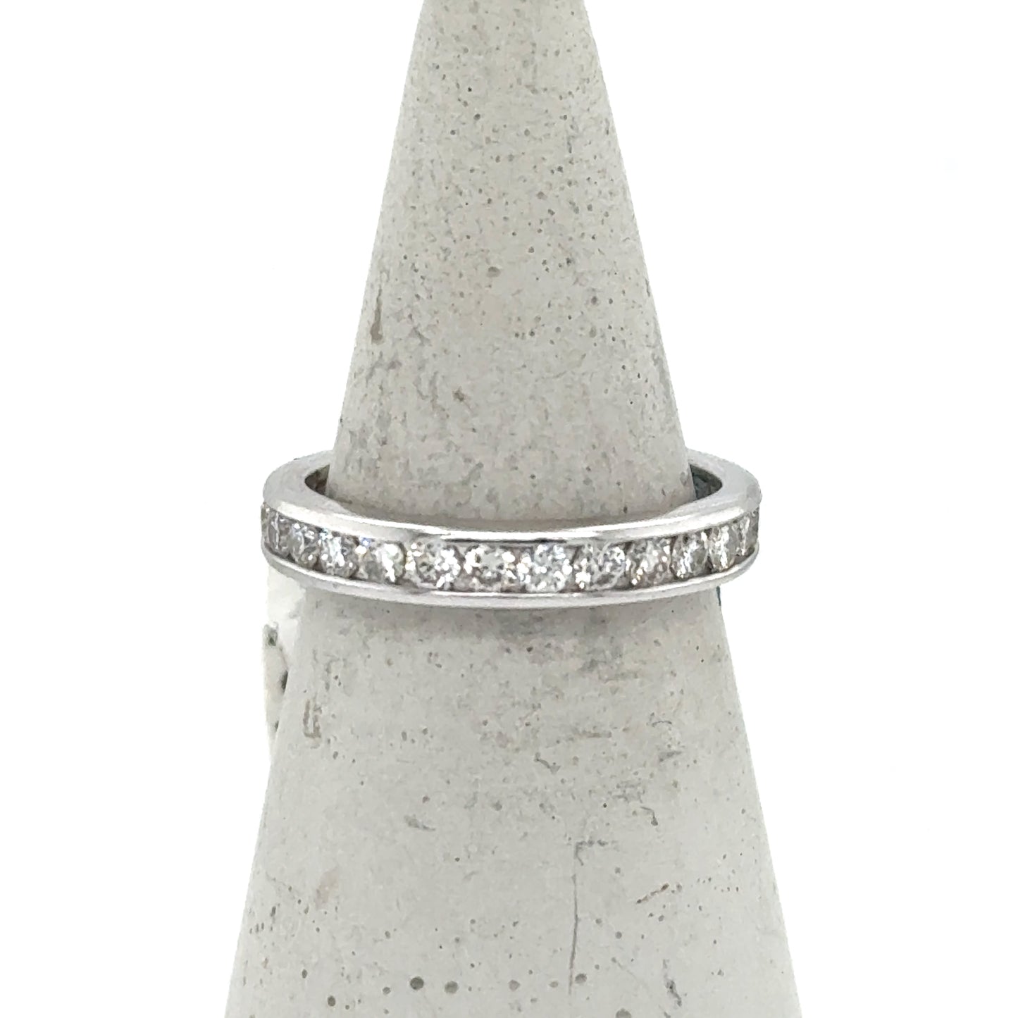 White gold eternity band with channel-set round diamonds around the ring.
