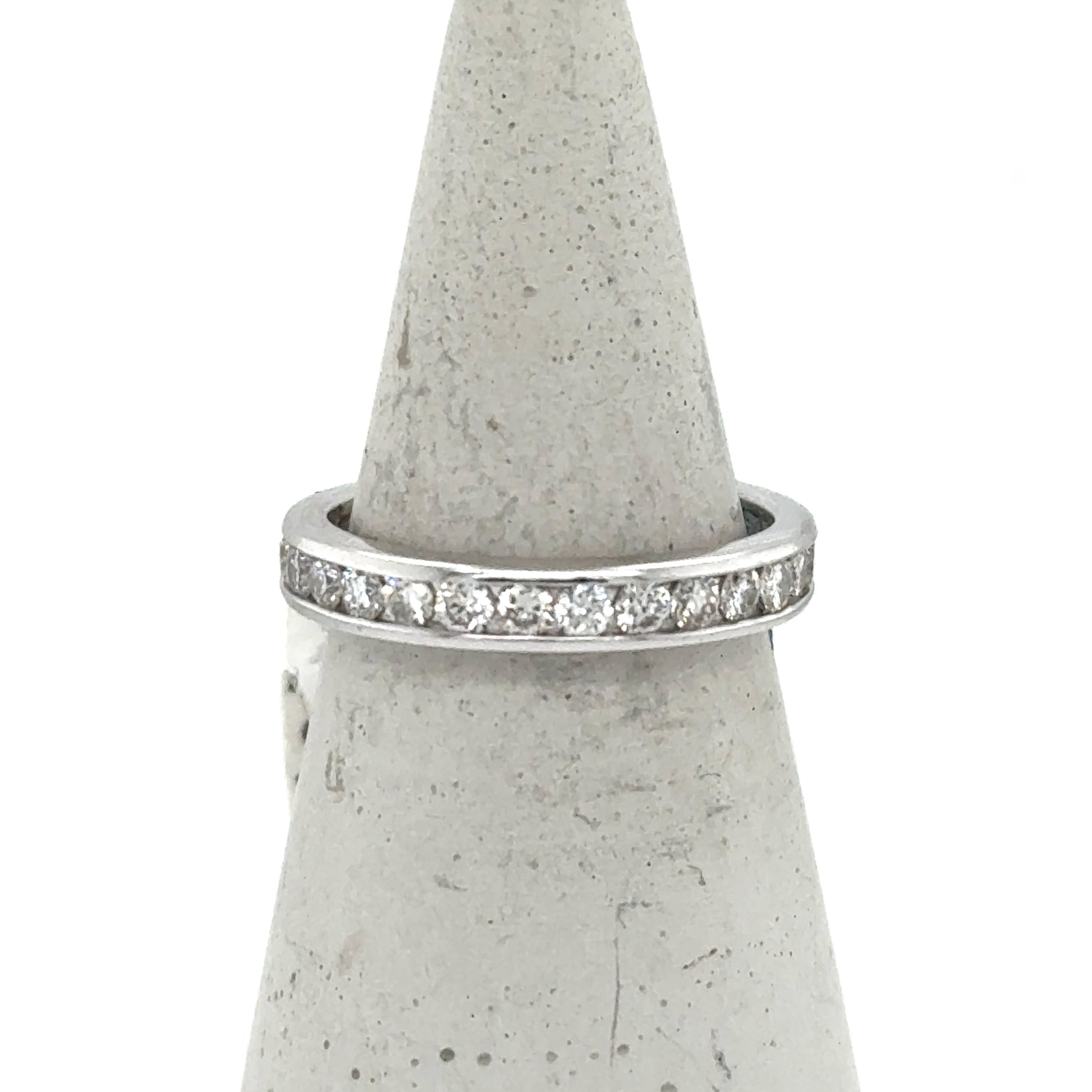 White gold eternity band with channel-set round diamonds around the ring.