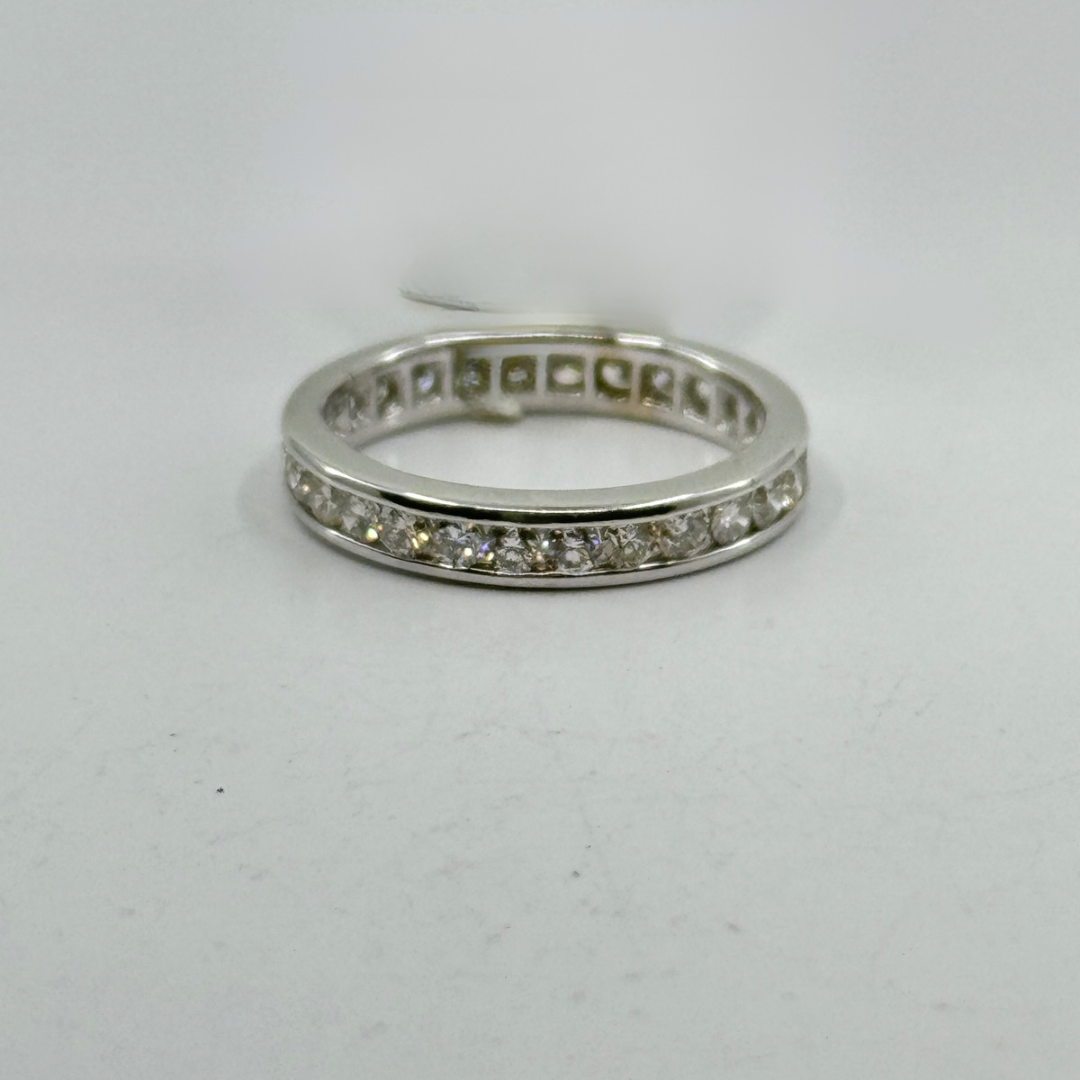 14K white gold eternity band with round diamonds in a channel setting.