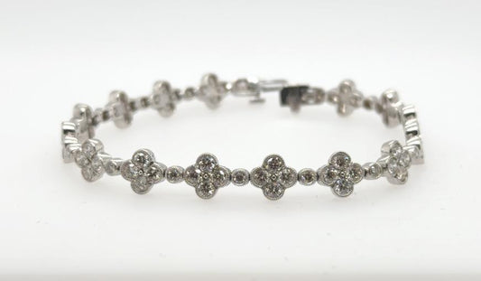 14K white gold tennis bracelet with diamond clover links and milgrain detailing.