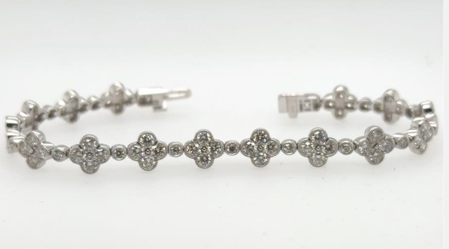 14K white gold tennis bracelet with clover-shaped diamond links and box clasp.
