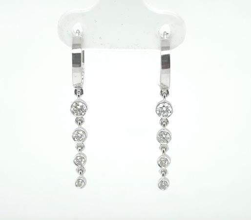 14K white gold hoop earrings with bezel-set graduated round diamond dangles.