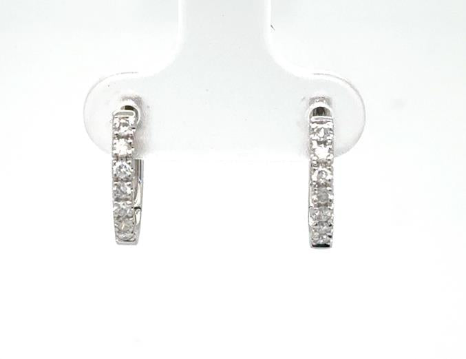 14K white gold huggie hoop earrings with prong-set round diamond fronts.