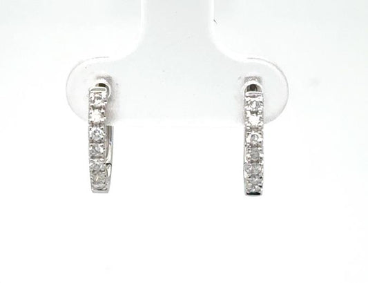 14K white gold huggie hoop earrings with prong-set round diamond fronts.