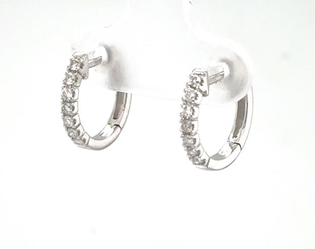 14K white gold huggie hoop earrings with prong-set round diamonds on the front.