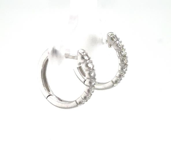 14K white gold huggie hoop earrings with prong-set round diamond fronts.