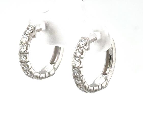 14K white gold huggie hoop earrings with prong-set round diamonds on front.