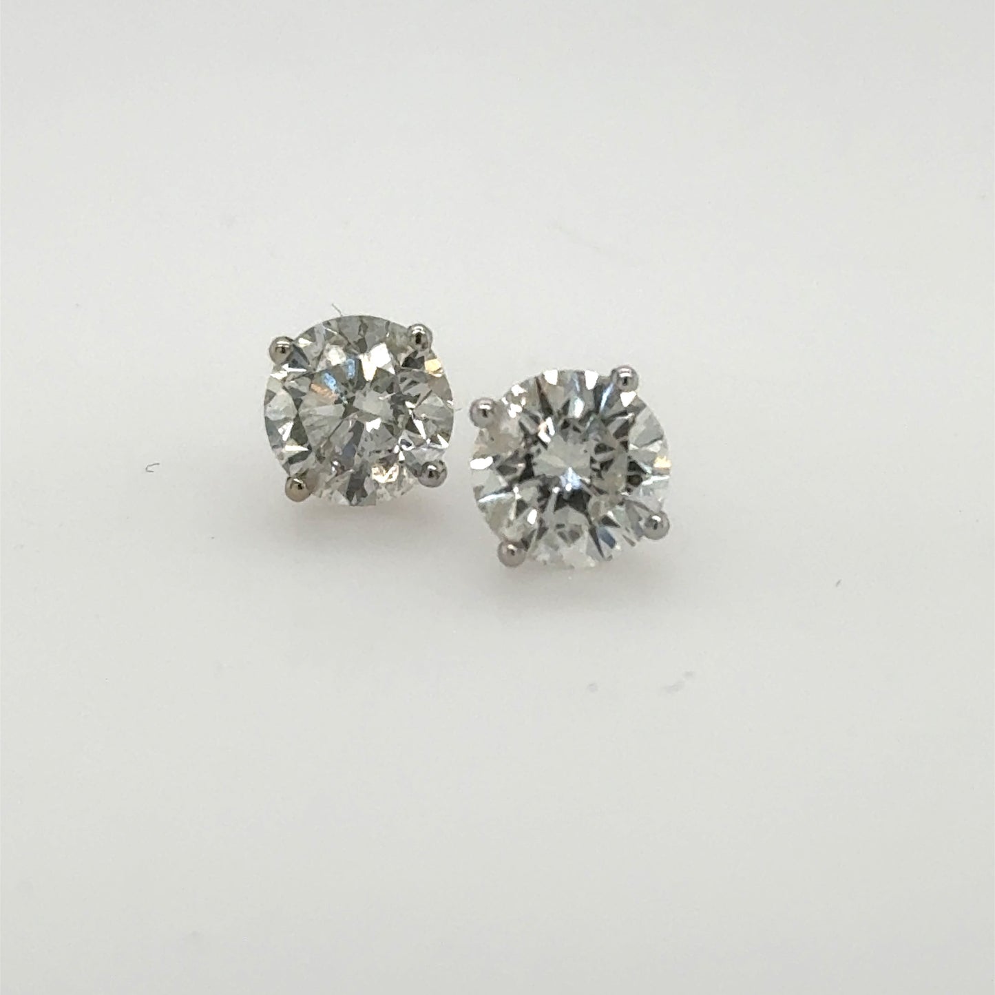 Round diamond stud earrings in 14K white gold four-prong martini settings.