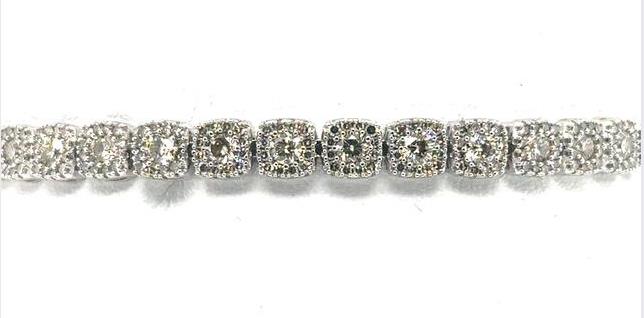 14K white gold tennis bracelet with round diamonds in halo link settings.