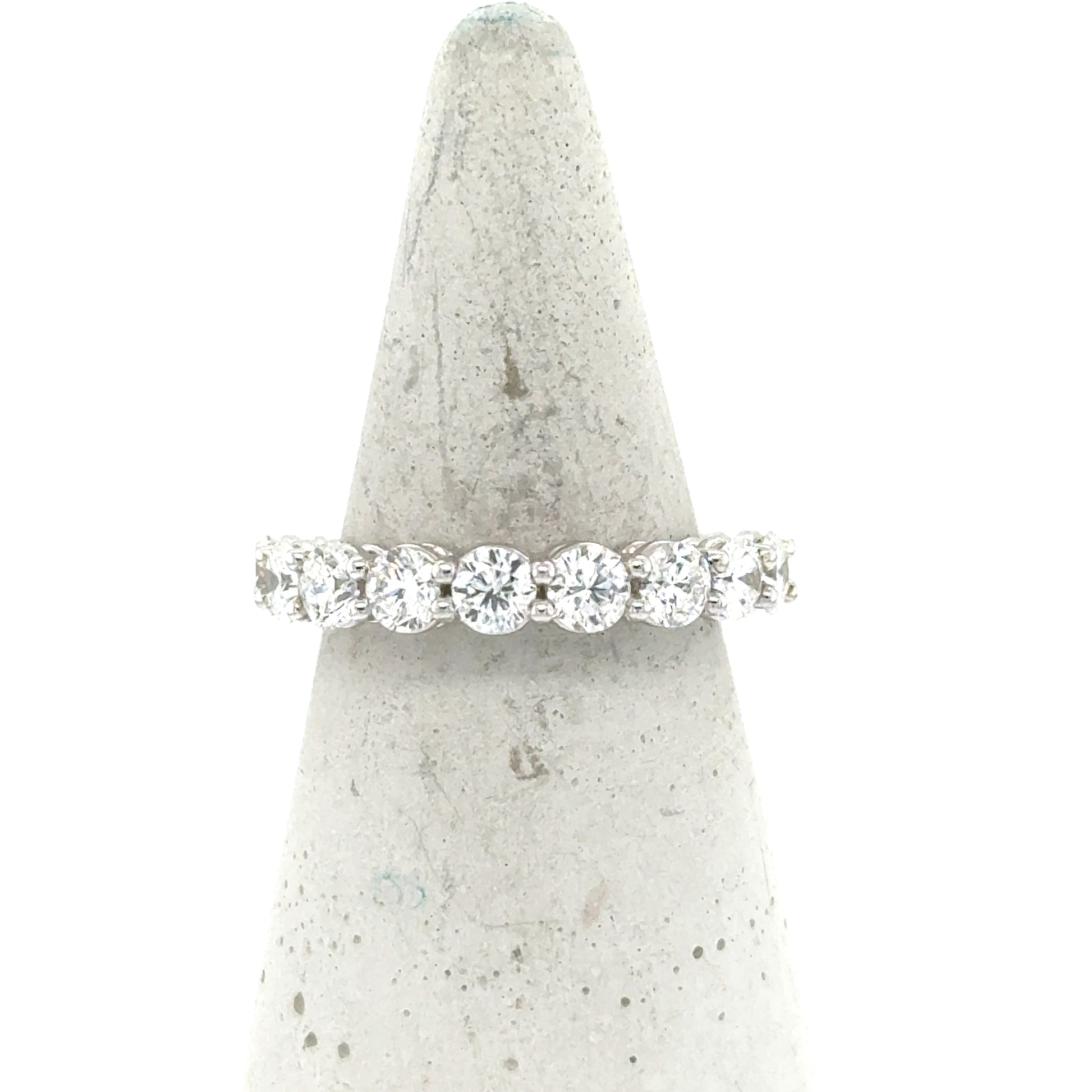 18K white gold band with nine round diamonds in shared-prong setting.
