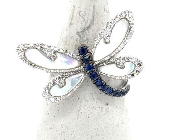 White gold dragonfly ring with mother‑of‑pearl wings, diamond outlines, and sapphire body.