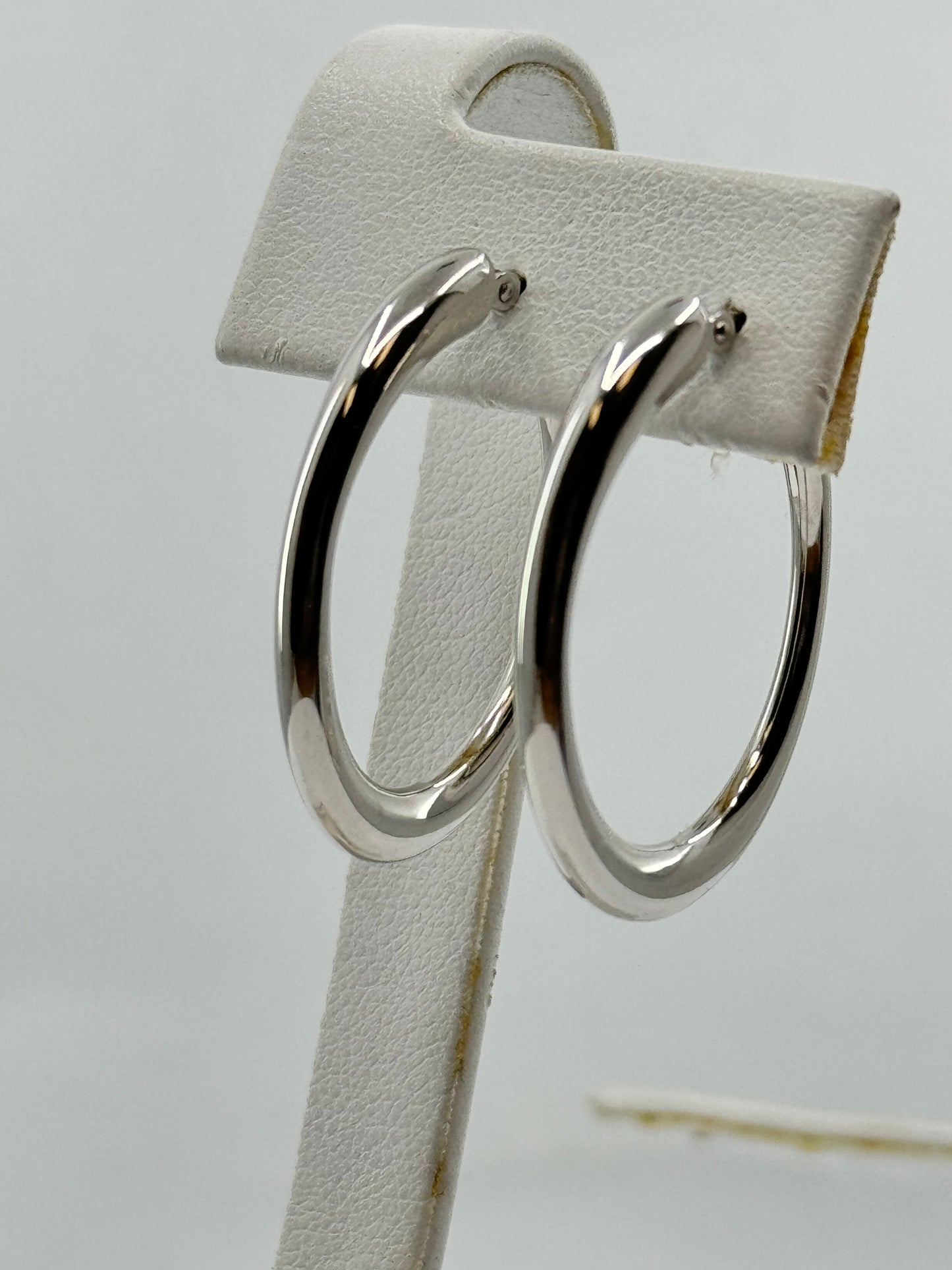 Polished 14K white gold oval hoop earrings for pierced ears.