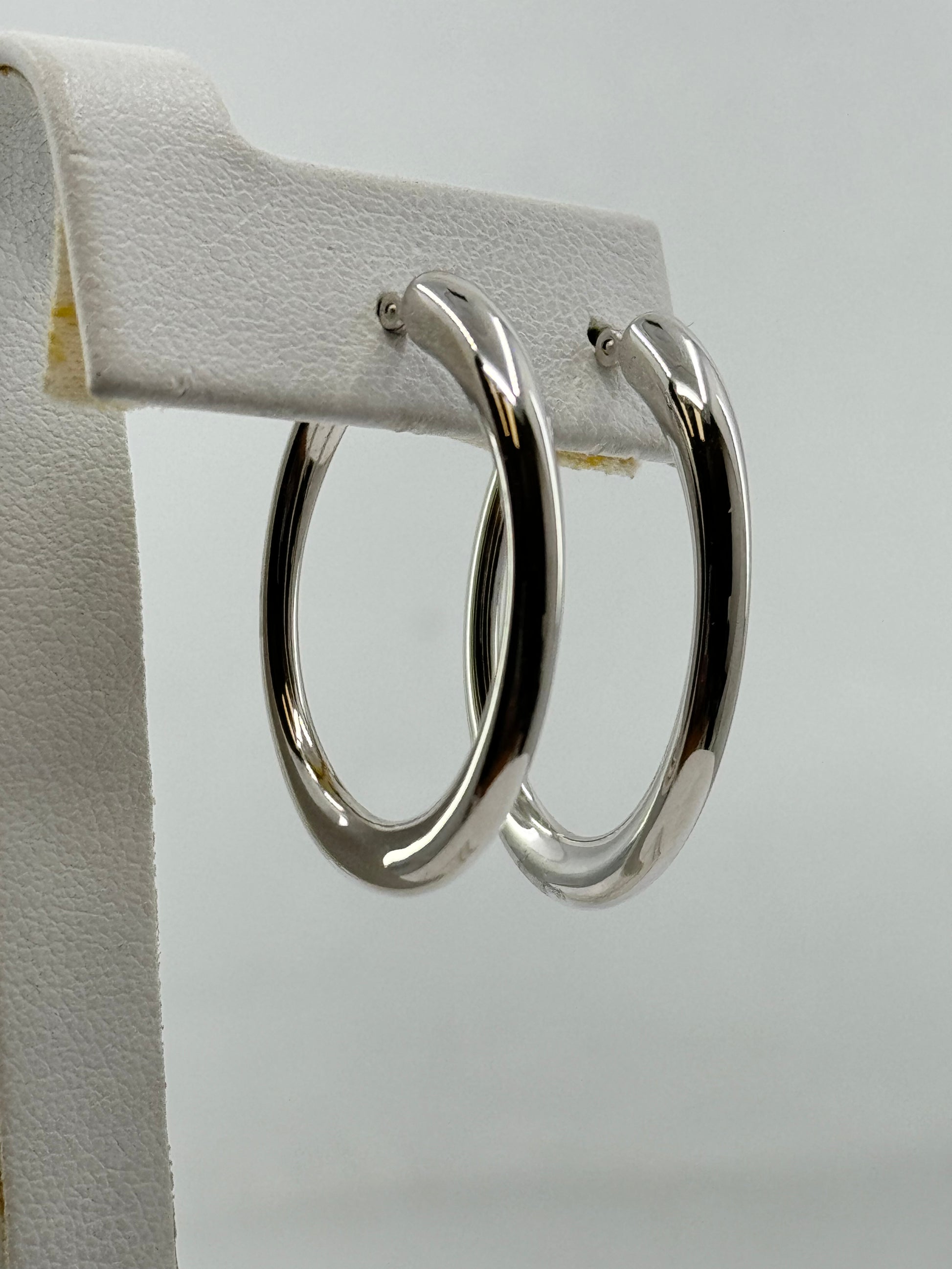14K white gold oval hoop earrings with polished finish for pierced ears.