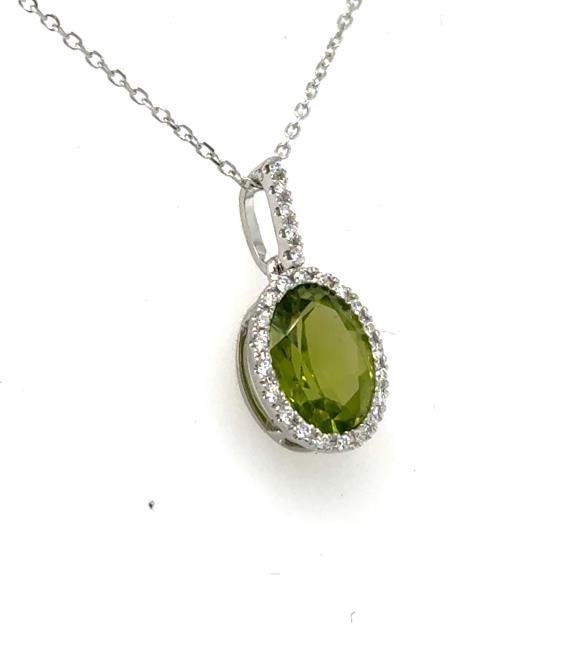 Oval green peridot halo pendant in 14K white gold with diamond-accented bail.