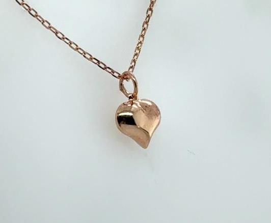 Small puffed heart pendant on an 18-inch rolo chain in rose-toned metal.