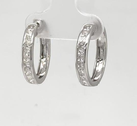 White gold hoop earrings with channel-set princess-cut diamonds along the front.