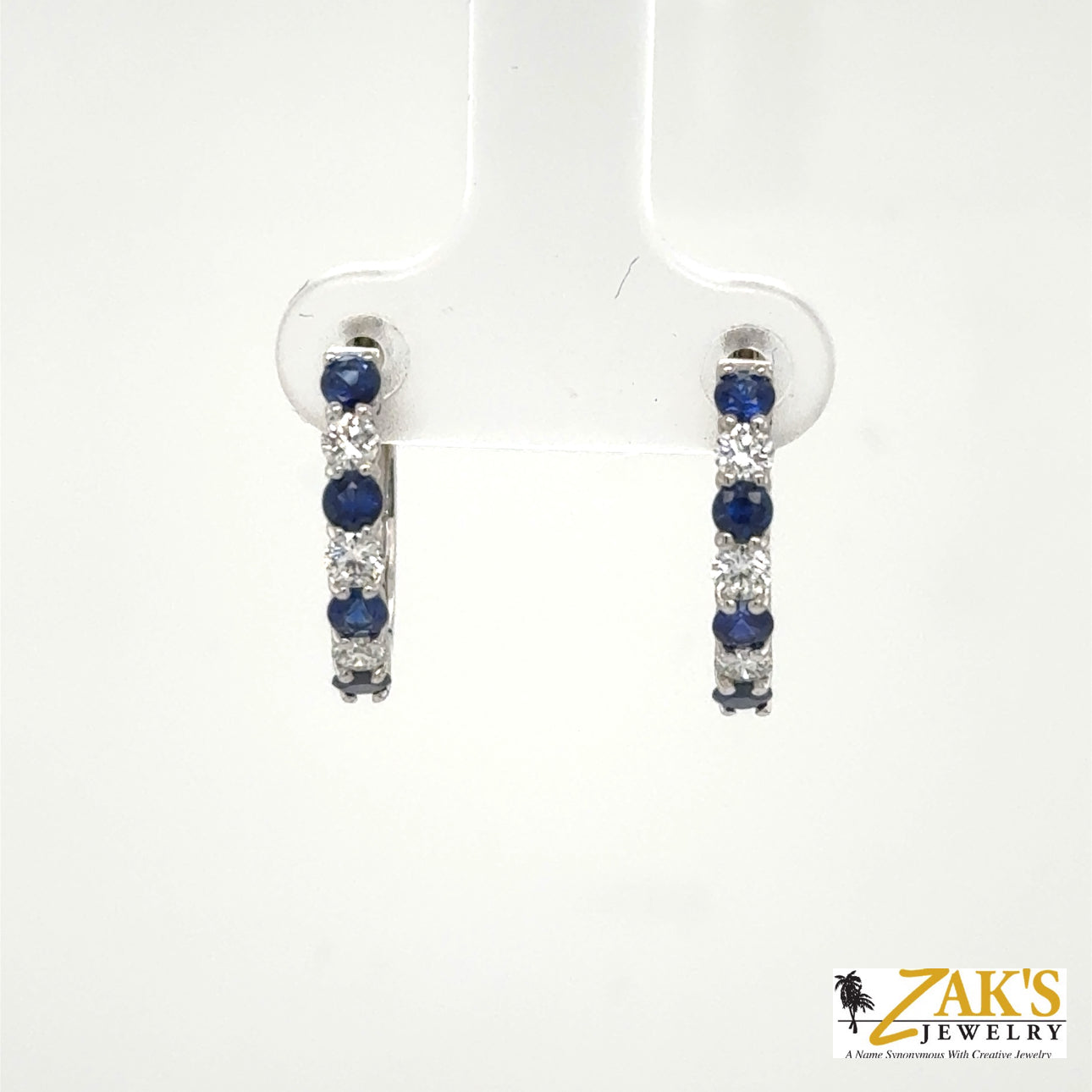 14K white gold small hoop earrings with alternating round blue sapphires and diamonds.