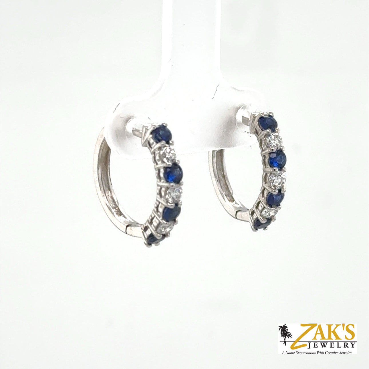 14K white gold hoop earrings with alternating round blue sapphires and diamonds.