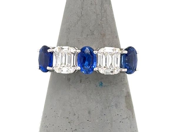14K white gold band with alternating oval blue sapphires and baguette diamond clusters.