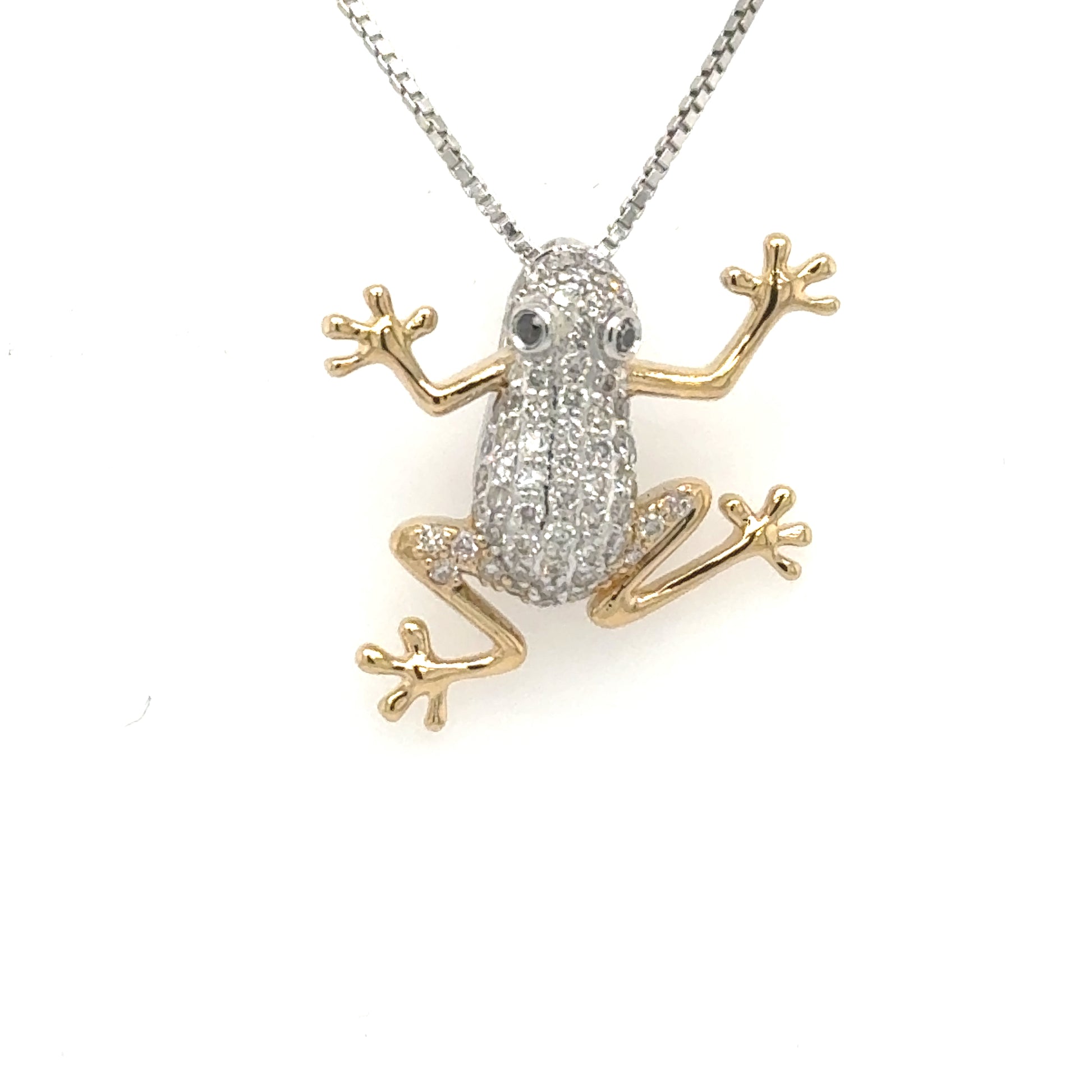 Two-tone gold frog pendant with diamond pavé body and blue sapphire eyes.