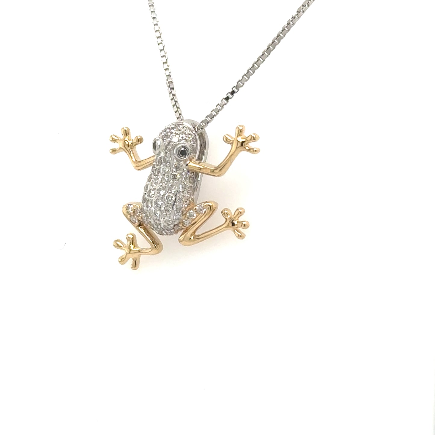 Two-tone gold frog pendant with pavé diamond body and gemstone eyes.