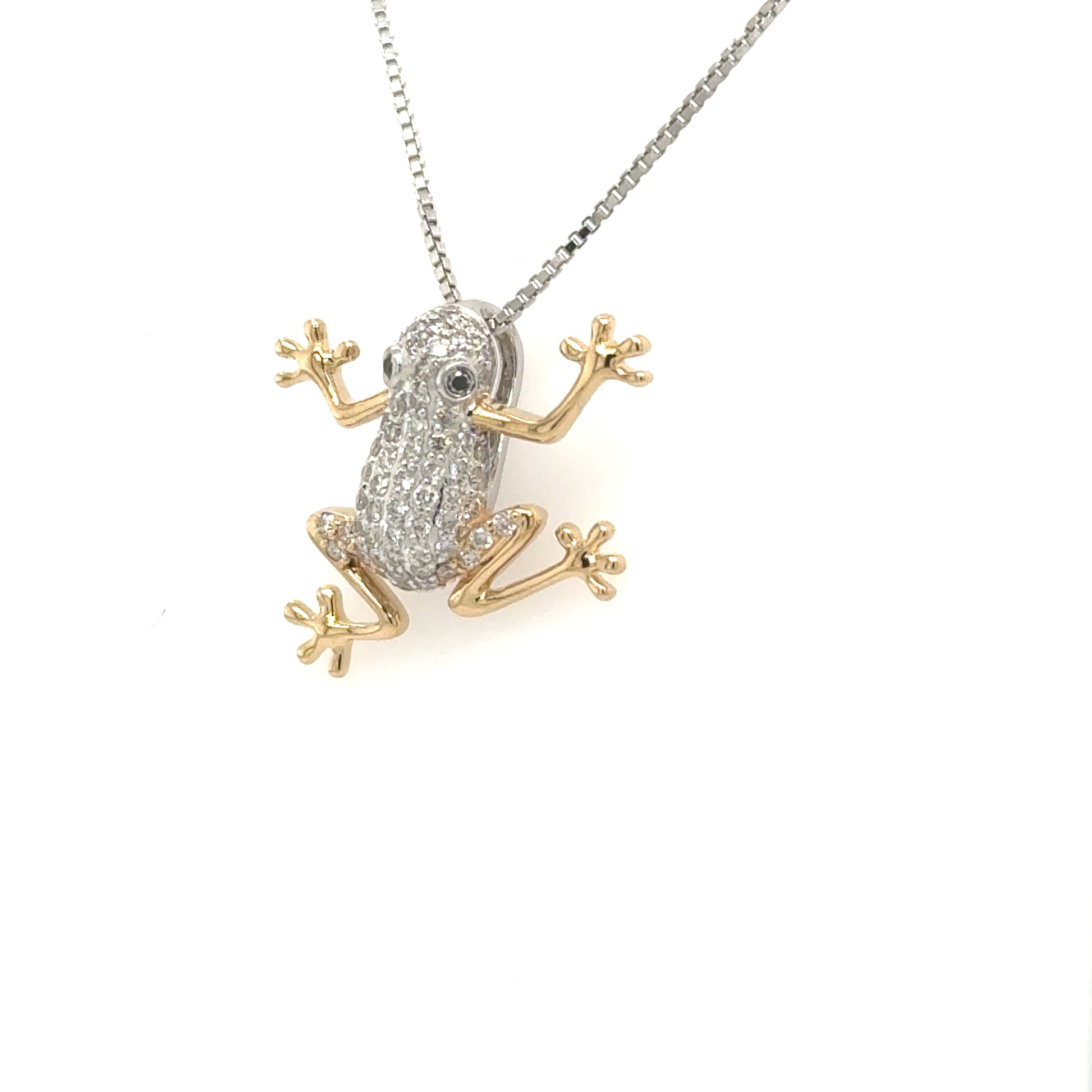 Two-tone gold frog pendant with pavé diamond body and gemstone eyes.