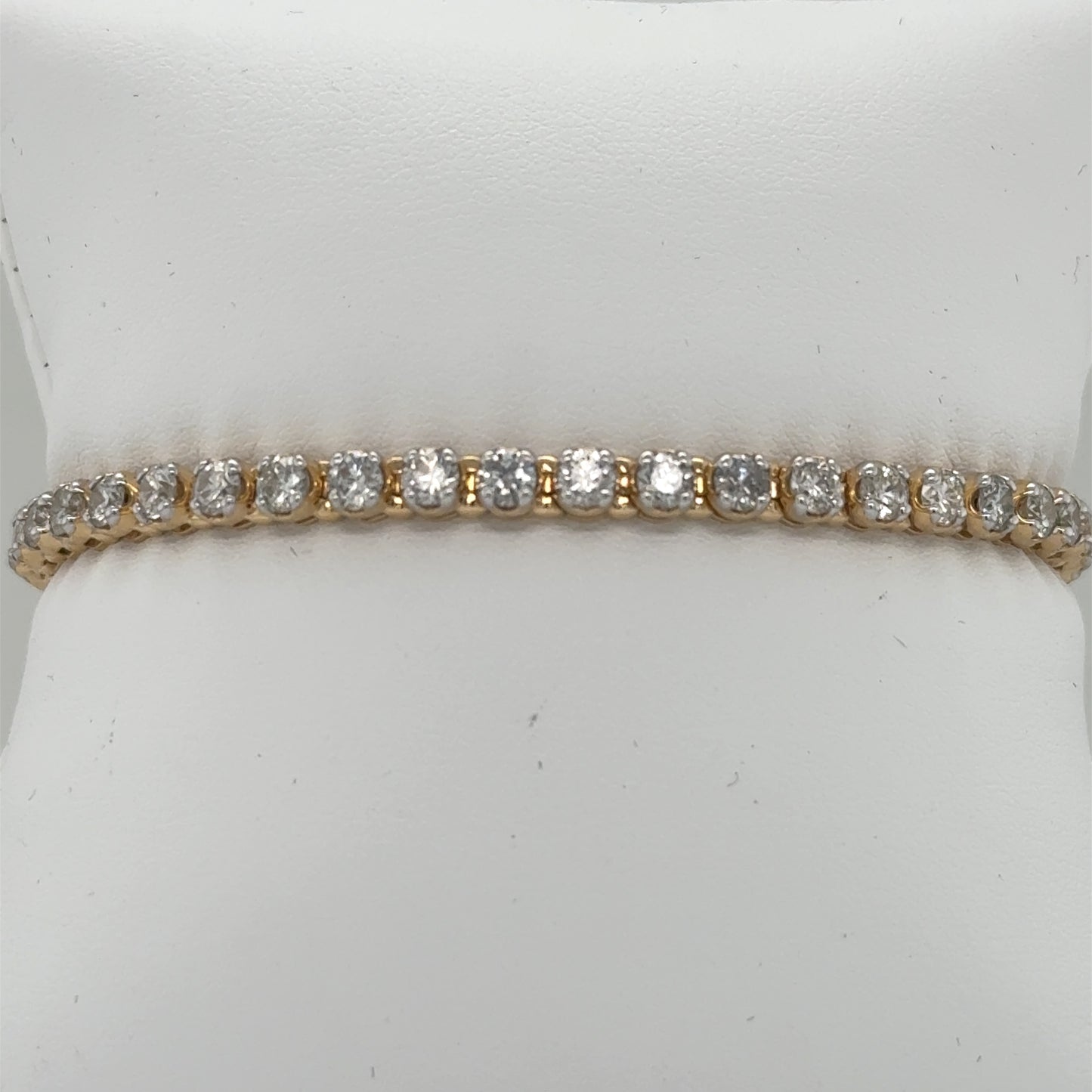 14K yellow gold tennis bracelet with round diamonds in four-prong settings.