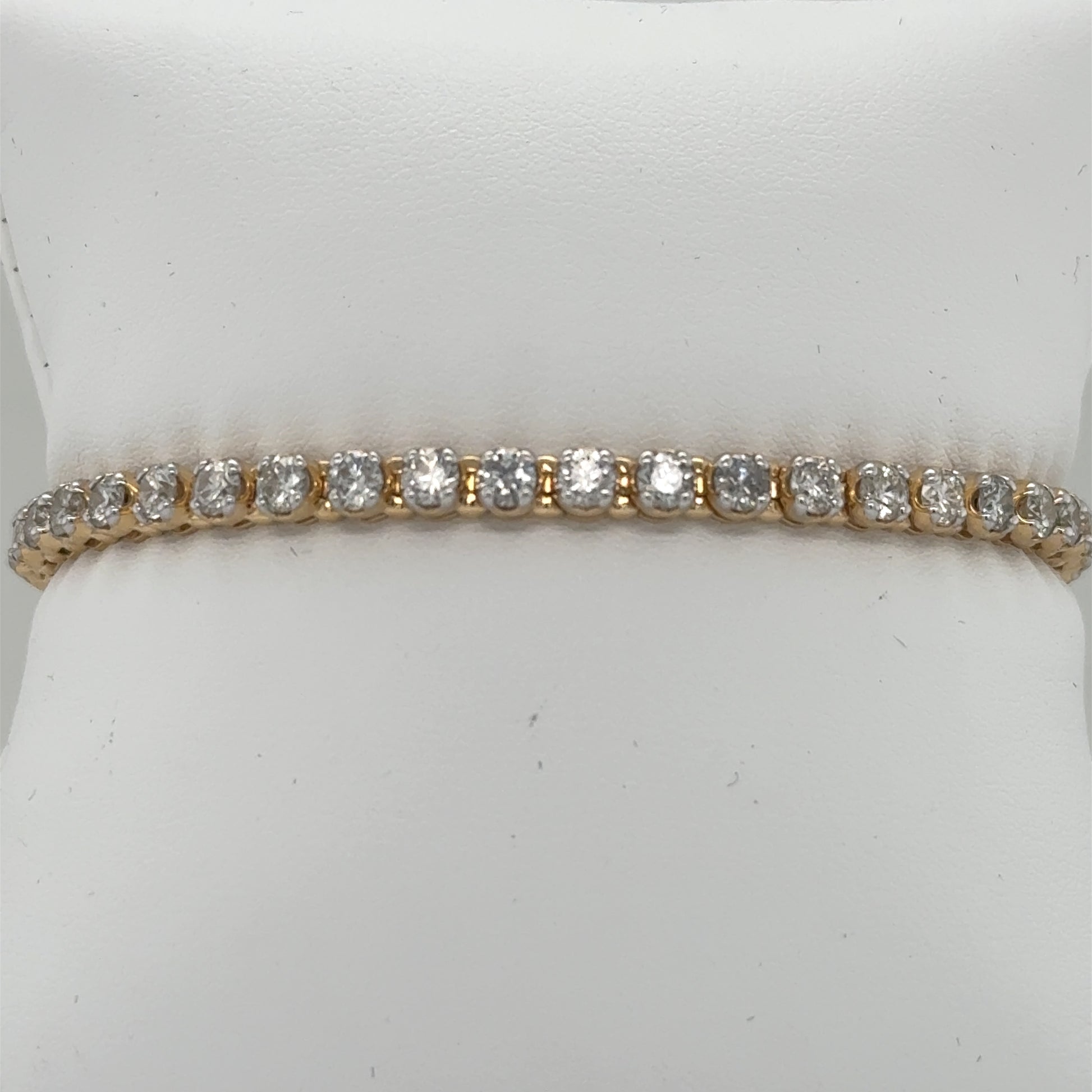 14K yellow gold tennis bracelet with round diamonds in four-prong settings.
