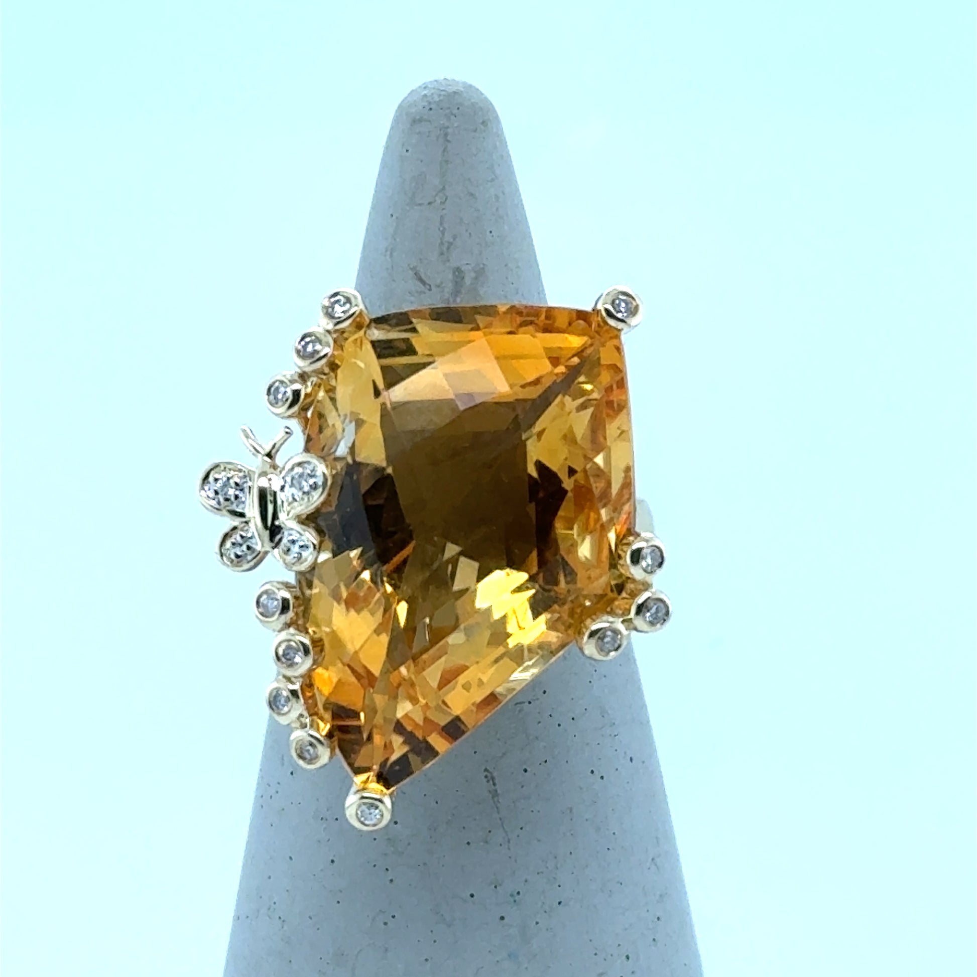 14K yellow gold ring with large fantasy-cut citrine and diamond-accented prongs, butterfly detail.