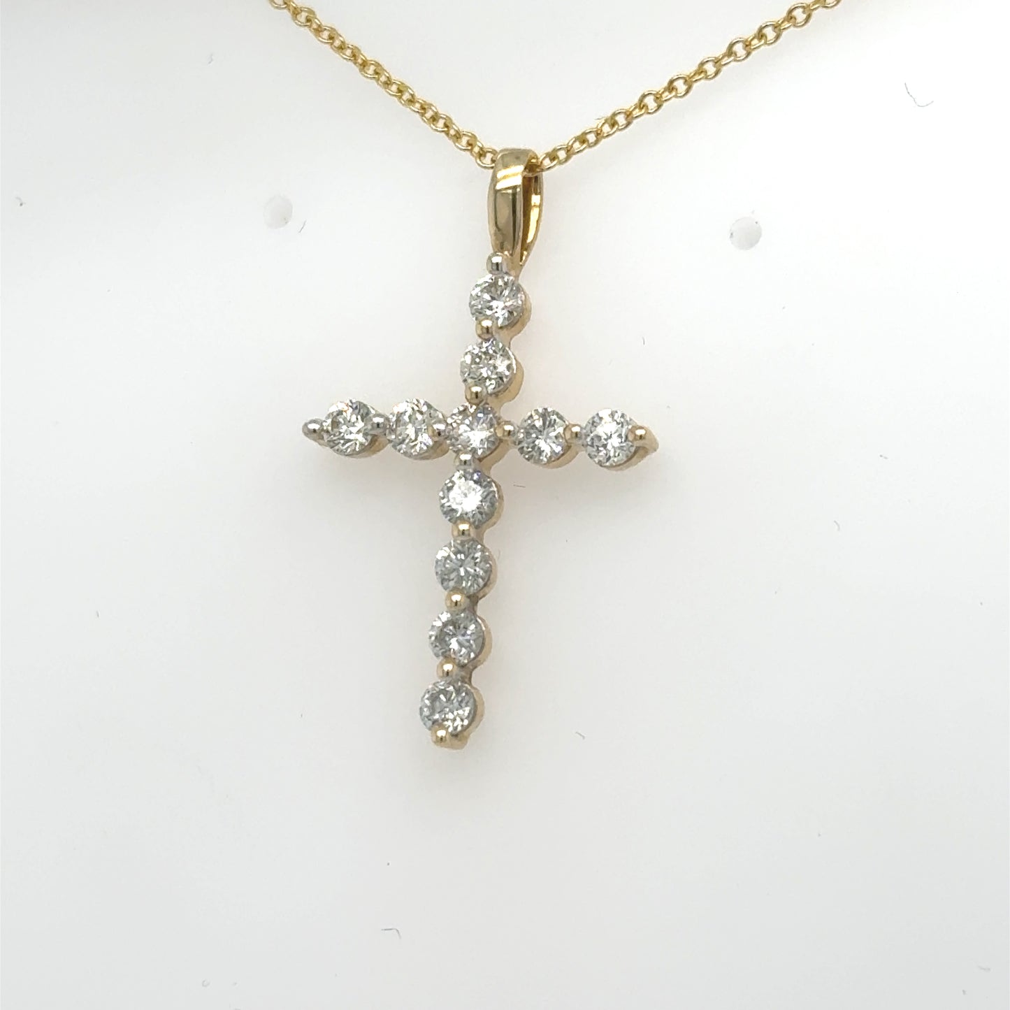 14K yellow gold cross pendant with round diamonds in shared prong settings.
